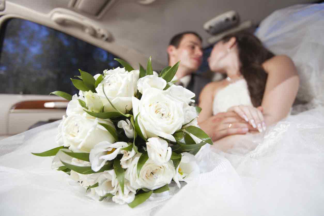 bride and groom in back of limo